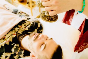 Emma holding tinghsa bells during sound therapy with a client