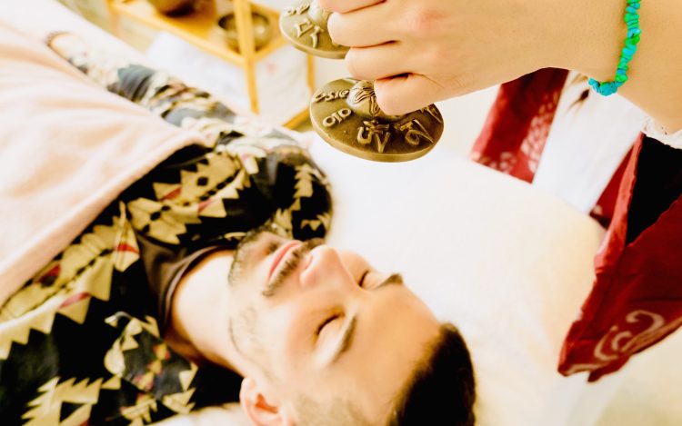 Emma holding tinghsa bells during sound therapy with a client