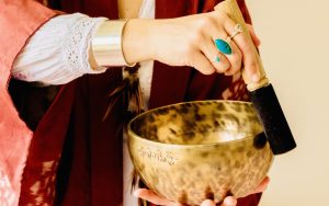 Emma, ayurvedic specialist playing the Tibetan singing bowl around the rim
