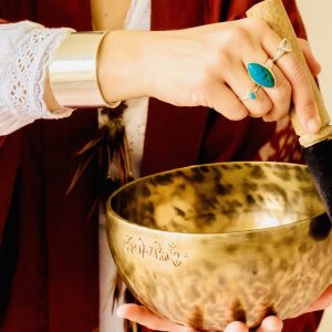 Emma, ayurvedic specialist playing the Tibetan singing bowl around the rim