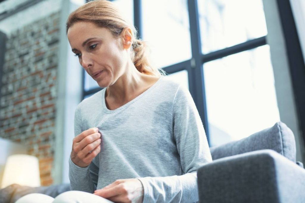 A woman suffering from menopause symptom of hot flashes and sweating lots because of the menopause