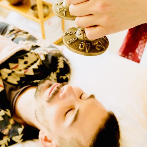Emma holding tinghsa bells during sound therapy with a client